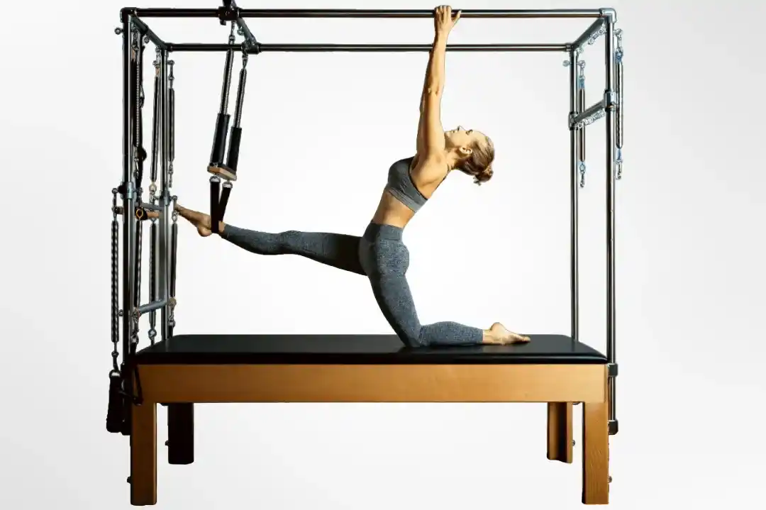 Chica haciendo ejercicios en el cadilac de pilates.