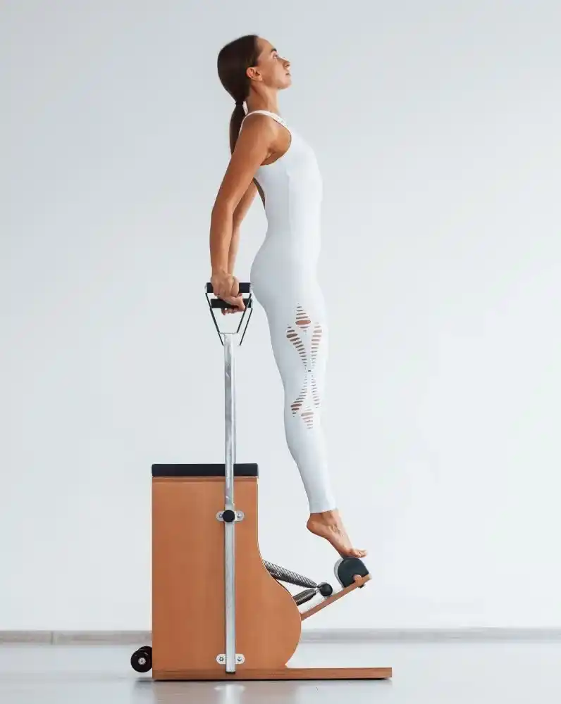 Alumna haciendo ejercicios en la silla de pilates.